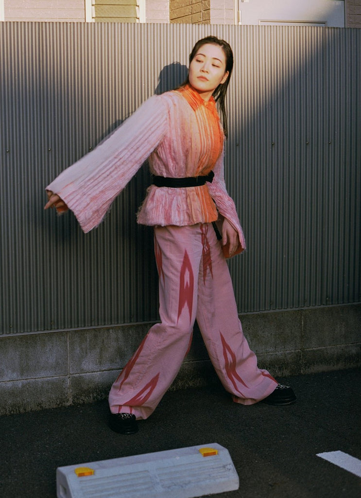 woman wearing pink kimono jumpsuit and multi-layered pink peach white cropped kimono jacket